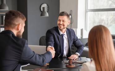 Male Lawyer with Client Shaking Hands in Office