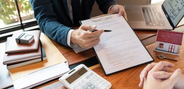 Buyer Signing a Real Estate Contract with a Lawyer